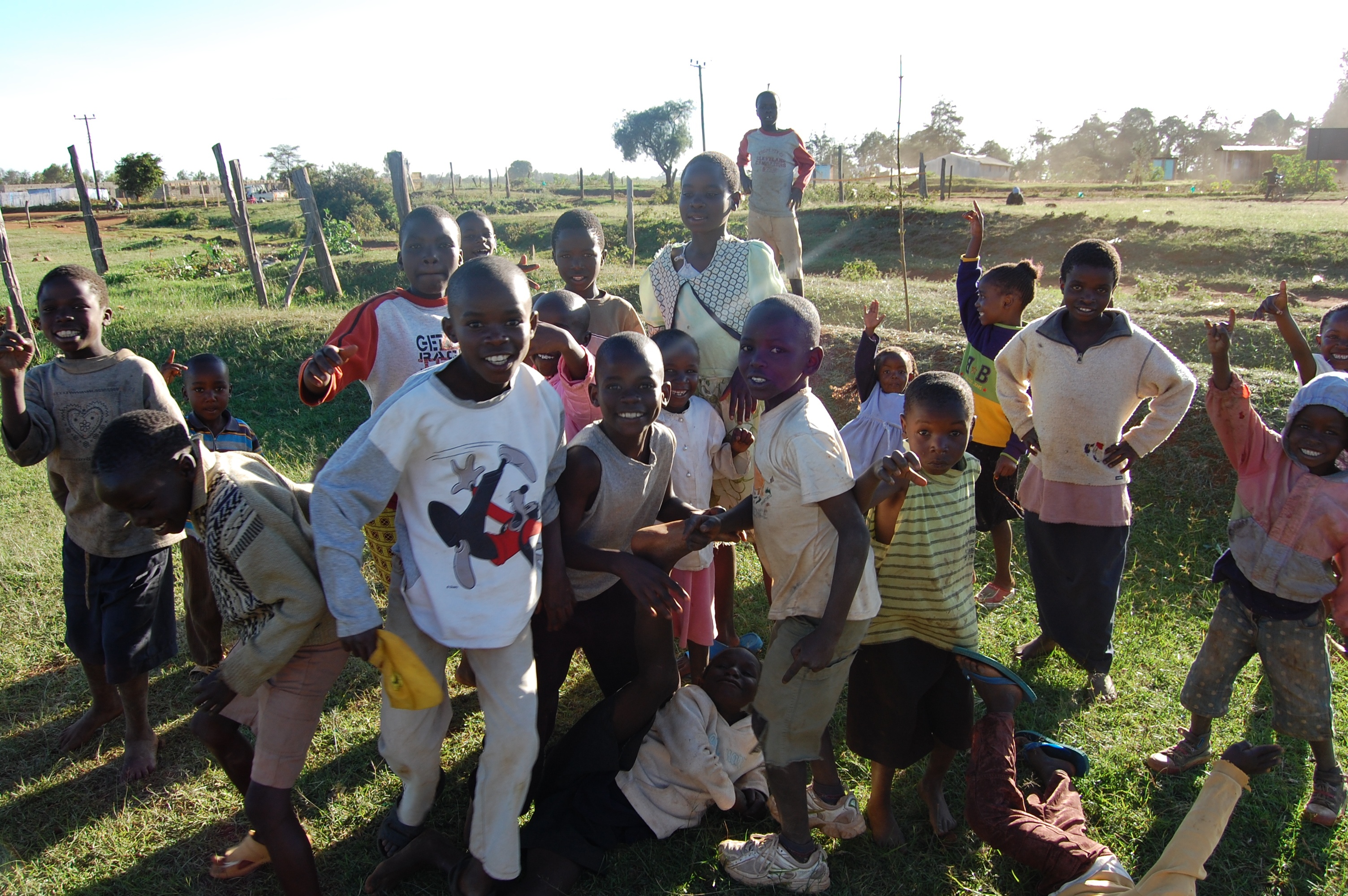 Large joyful group of children in a rural grassy field