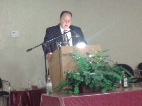 A man speaks from a lectern in a room